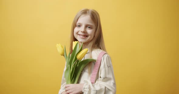 Beautiful Girl Holds Tulip Flowers in Her Hand She Smiles on Yellow Background