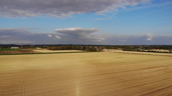 Aerial view of golden fields with brown mold close to Sejerøbugten in Odsherred.