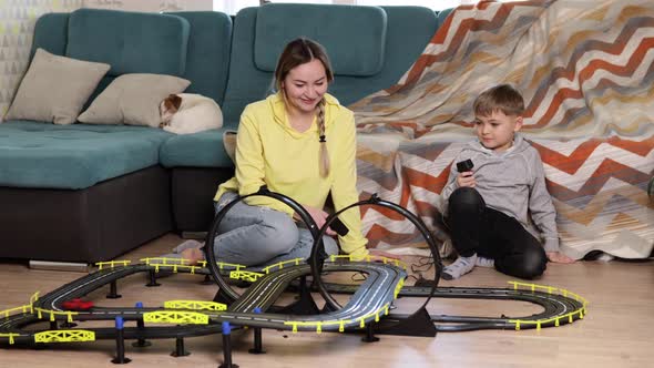 Mom and Little Son Play Racing on the Carpet at Home Have Fun and Hug