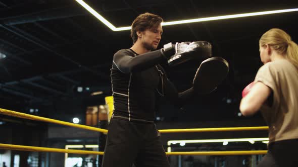 Anxious Sport Woman Boxing in Sport club.Male and Female Boxers Training at Gym