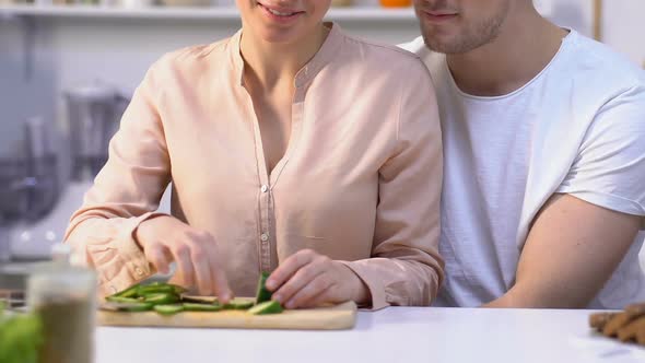 Attractive Girl Feeding Beloved Boyfriend Vegetables, Happy Couple in Kitchen