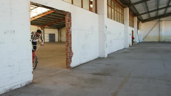 BMX riders in an empty warehouse