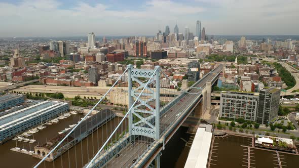 Aerial rotating view of Philadelphia Ben Franklin Bridge and skyline in the summer with cars and tra