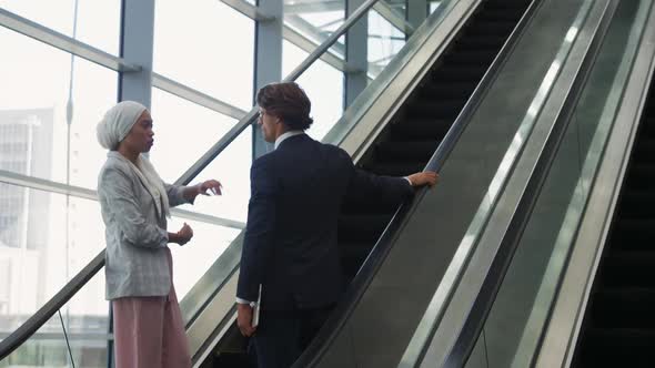 Young business people on an escalator in a modern building