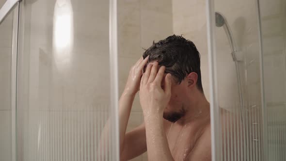 Brunet Man Is Washing Head in a Shower in Home, Close-up