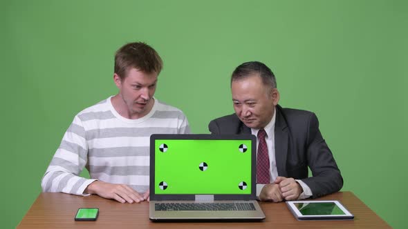 Mature Japanese Businessman and Young Scandinavian Businessman Working Together