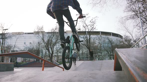 BMX Rider Doing Tricks in Street Plaza Bicycle Stunt Rider in Cocncrete Skatepark Super Slow Motion