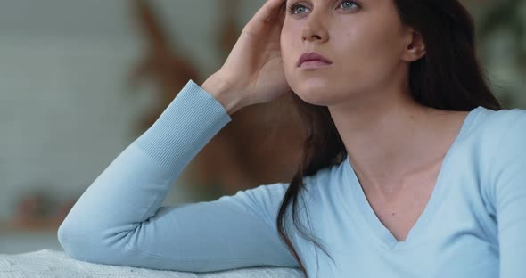 Tracking Shot Portrait of Young Depressed Woman Sitting Alone at Home, Looking Away and Thinking