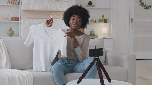 Young African Female Blogger Sitting on Couch Recording Video on Camera Sharing Shopping Experience