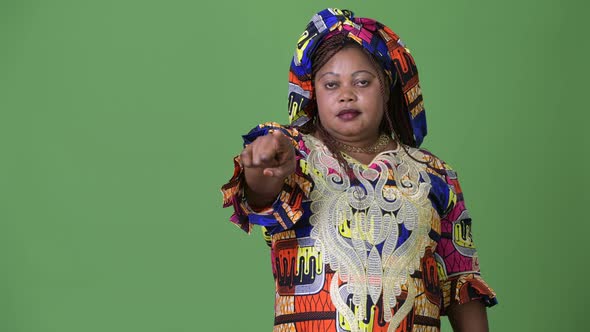 Overweight Beautiful African Woman Wearing Traditional Clothing Against Green Background