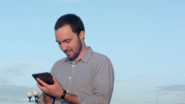 Man Using Tablet Computer at Sunset Time