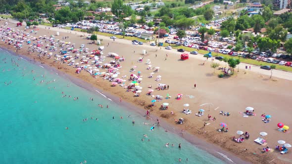 Colorful aerial view of a typical European beach called Adrasan full of people and umbrellas on a ho