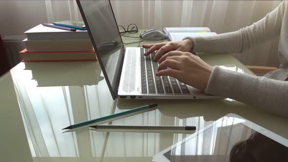 The girl working at home office hands on keyboard.