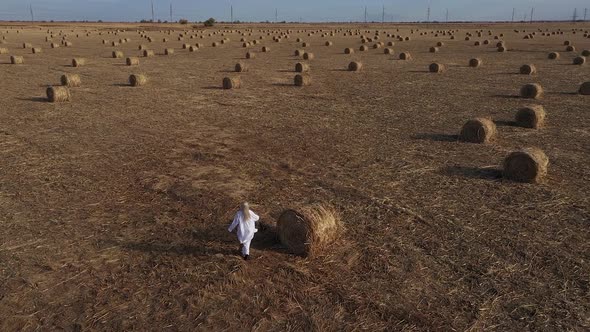 a girl in white runs across the field