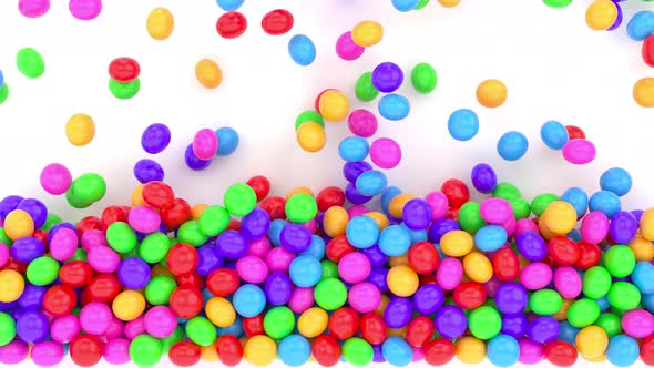 3D animation of a bunch of abstract colorful spheres and balls of candy rolling