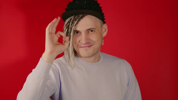 Young Handsome Man in Black Cap Showing Gesture of OK