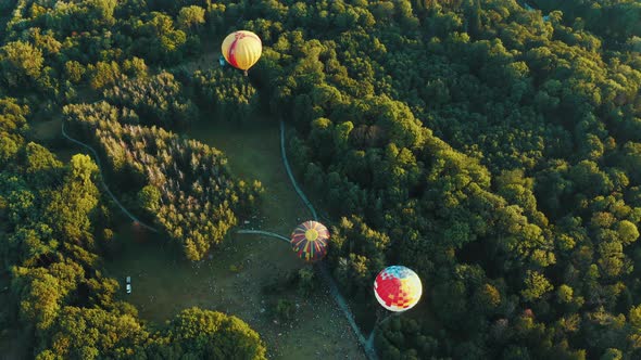 Aerial View of Three Hot Air Balloons Takes Off Among the Trees in the Park. Beautiful Sky and