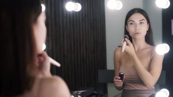 Adorable Cute Caucasian Girl Applying Powder While Preparing for Makeup