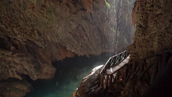 Drops Drip Into the Water in a Small Cave 