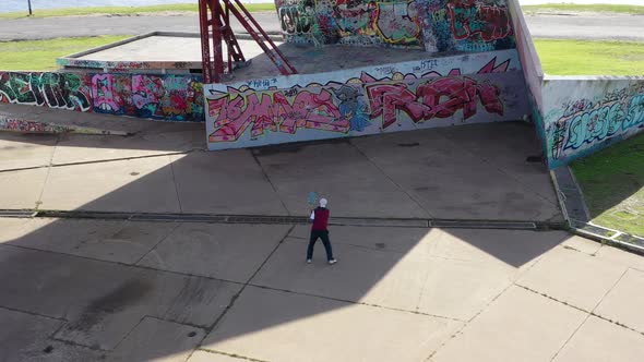 Man playing fronton tennis on a graffitied wall, public park, modern urban amphitheater. Vicente Lop