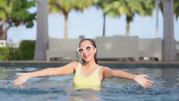 Young asian woman enjoy around outdoor swimming pool for leisure