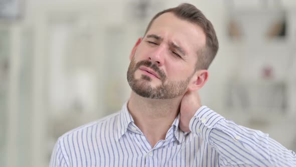 Portrait of Tired Young Man Having Neck Pain