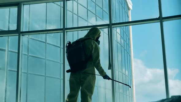 Sanitary Specialist Is Disinfecting a Large Window in Business Center. Disinfection, Sanitation