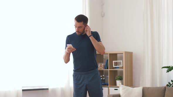 Man with Wireless Earphones Exercising at Home 