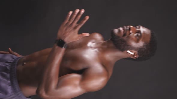 Sporty AfricanAmerican with Bare Breasts on an Isolated Dark Background