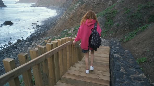 Young Woman Tourist Goes Down the Long Stairs to the Famous Volcanic Black Sand Beach Benijo in the