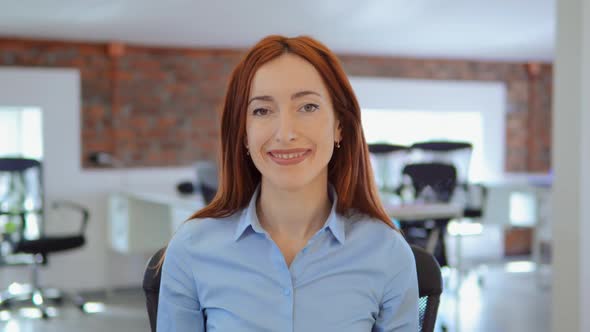 Cheerful Redhead Businesswoman Posing at Workplace