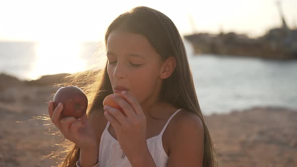 Charming Girl in Sunbeam Biting Apple and Peach Smiling