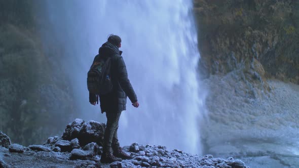 Man Traveler Under Famous Waterfall Kvernufoss in Iceland