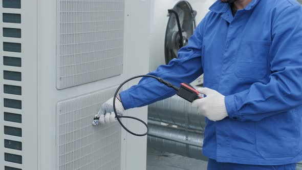 The technician uses a digital camera to check the clogging of the heat exchanger