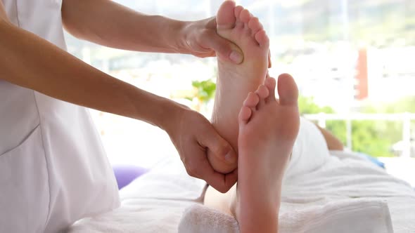 Close up of woman therapist massaging the feet of her patient