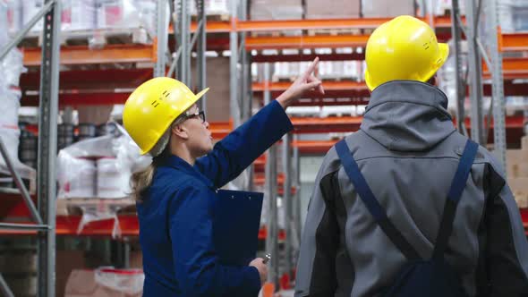 Warehouse Workers Walking and Discussing Work