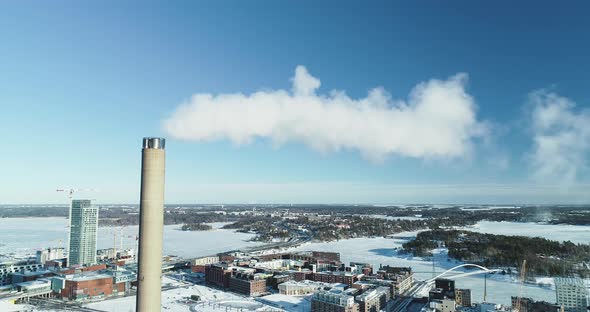 Static aerial shot of a flue-gas stack in Winter.
