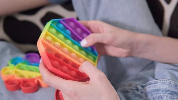 A Girl Plays with a Silicone POP IT Toy