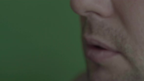 Cigarette in the Mouth of a Smoker. Close-up. Chroma Key. Green Background.