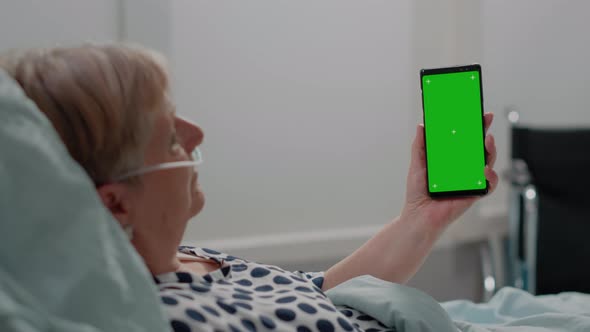 Close Up of Ill Patient Vertically Holding Green Screen on Smartphone