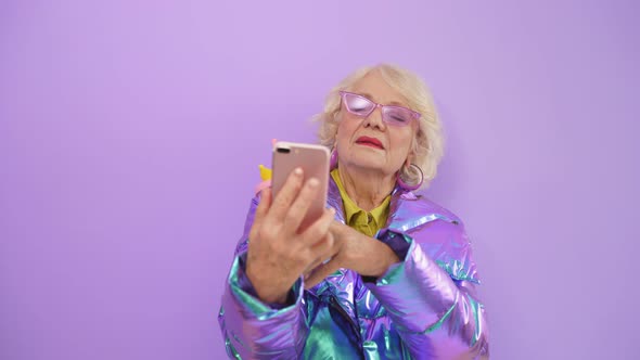 Close-up Portrait of an Elderly Woman Taking a Selfie on Her Smartphone.