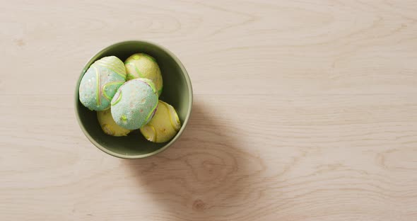 Video of decorated colorful easter eggs in bowl on a wooden surface