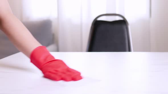 Closeup hands wearing red protective household gloves cleaning and disinfects table for protective C