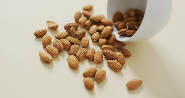 Video of almonds in a bowl on white background