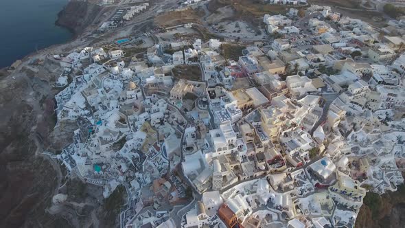 Flying over beautiful and famous Oia on Santorini Island in Greece during sunrise