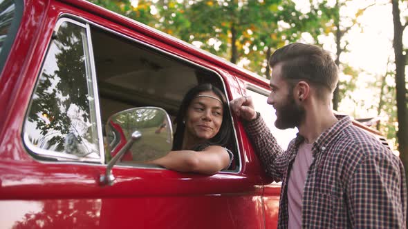 Happy Young Cheerful Mixed Race Couple Having Some Fun in Retro Hippie Minibus in Forest