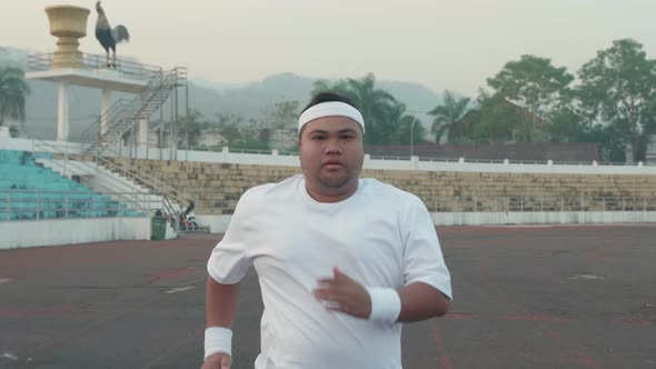 Fat Man Jogging At Stadium