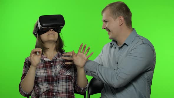 Man and Woman Using VR Headset Helmet To Play Game. Watching Virtual Reality 3D Video. Chroma Key