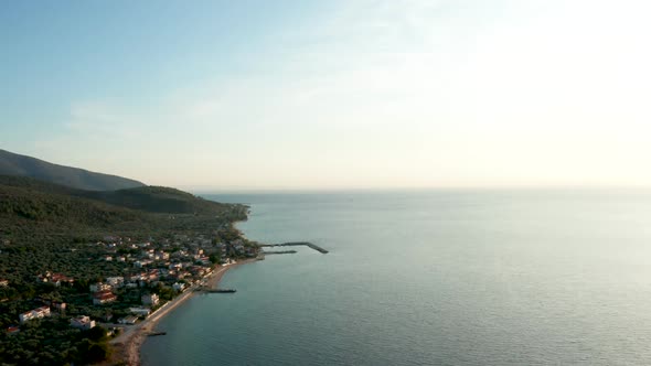 Drone Flying Over Sea with Turquoise Water and Houses Near the Coastline