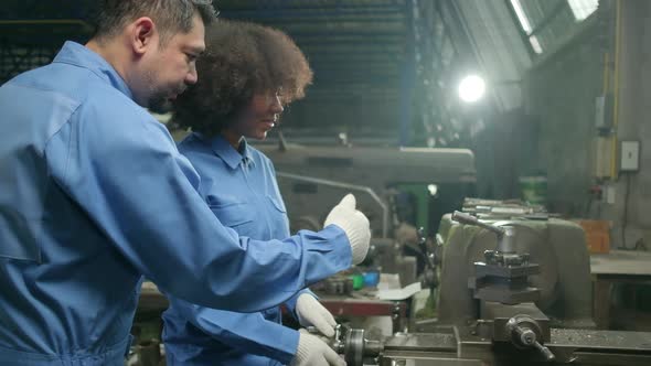 Two professional industry workers work in metalwork manufacturing factory.